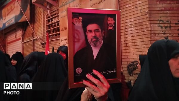 نگاهی به سیمای نورانی رهبر شهید در دست مردم