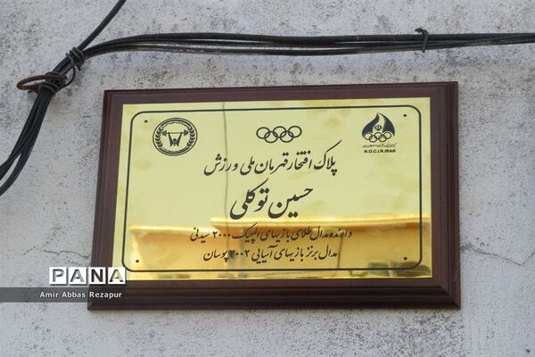 نصب پلاک افتخار المپین پهلوان حسین توکلی بر سردرب منزل