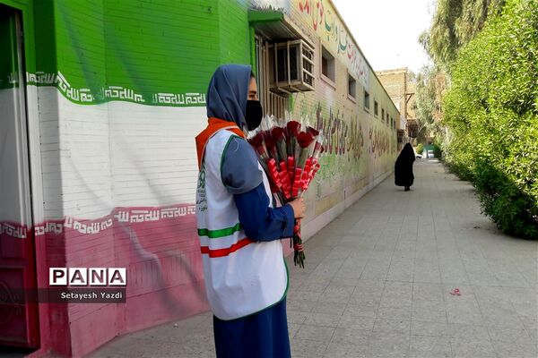 توزیع گل توسط دانش آموز پیشتاز دبیرستان هیات امنایی پاینده بمناسبت میلاد پیامبر (ص)