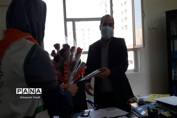 توزیع گل توسط دانش آموز پیشتاز دبیرستان هیات امنایی پاینده بمناسبت میلاد پیامبر (ص)