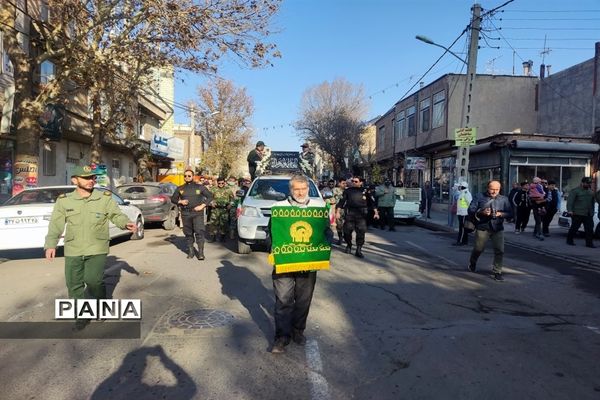 تشییع پیکر مطهر شهید گمنام با حضور خادمیاران و پرچم متبرک رضوی در میانه