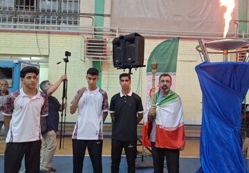 روشن‌شدن مشعل افتتاحیه مسابقات ورزشی دانش‌آموزان منطقه شش کشور به دست پدر شهیده لامری